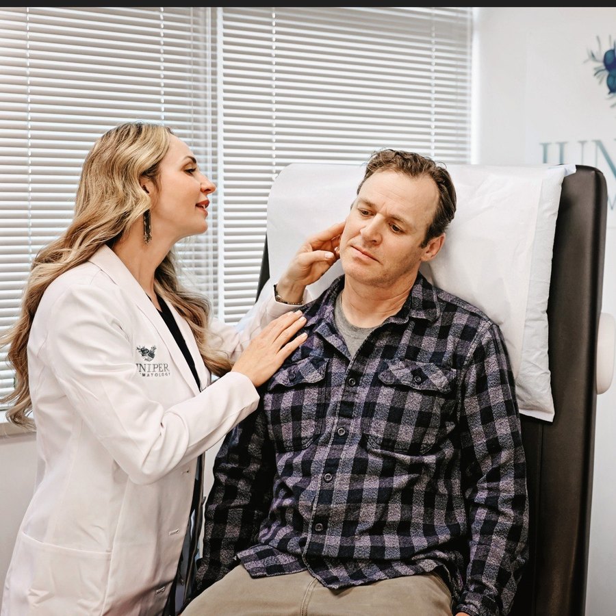 Dr. Pivik examining a male patient's hair and scalp at Juniper Dermatology